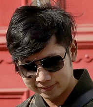 Vorayuth "Boss" Yoovidhya walks to get in a car as he leaves a house in London in this file photo. A Thai court on Tuesday, August. 25, 2020 issued a new arrest warrant for an heir to the Red Bull energy drink fortune./Credit:	Matt Dunham/AP