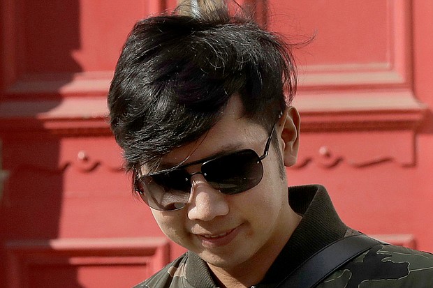 Vorayuth "Boss" Yoovidhya walks to get in a car as he leaves a house in London in this file photo. A Thai court on Tuesday, August. 25, 2020 issued a new arrest warrant for an heir to the Red Bull energy drink fortune./Credit:	Matt Dunham/AP