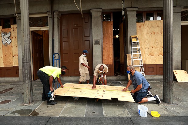 Workers board up windows in the French Quarter in anticipation of Hurricane Marco and Tropical storm Laura./Credit:	Sean Gardner/Getty Images
