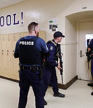 Law enforcement and first responders from Cumberland and York Counties participate in a regional active shooter training at Deering High School led by the District II Training Council. Law enforcement officers check a classroom during the drill./Credit:	Derek Davis/Portland Press Herald/Getty Images