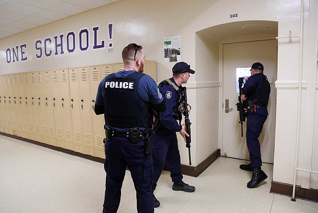 Law enforcement and first responders from Cumberland and York Counties participate in a regional active shooter training at Deering High School led by the District II Training Council. Law enforcement officers check a classroom during the drill./Credit: Derek Davis/Portland Press Herald/Getty Images