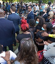 Jacob Blake Sr. (red plaid shirt) and Julia Jackson (standing beside him), the parents of Jacob Blake, attend a news conference tuesday in Kenosha, Wis. Violent unrest broke out after video of the shooting of Jacob Blake, 29, was widely disseminated on social media sunday. Mr. Blake was shot in the back several times by a Kenosha police officer. According to his father, Mr. Blake is paralyzed from the waist down.