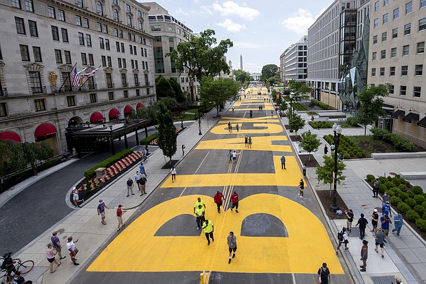 The Washington Monument and the White House are visible behind the words Black Lives Matter sign that has been painted in bright yellow letters on the 16th Street by city workers and activists, Friday, June 5, 2020, in Washington.