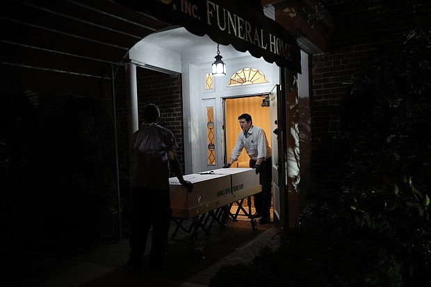 Omar Rodriguez (left) and Joseph Neufeld Jr. (right) carry a casket at the Gerard J. Neufeld funeral home in Queens, New York on April 29, 2020./Credit:	Tayfun Coskun/Anadolu Agency/Getty Images