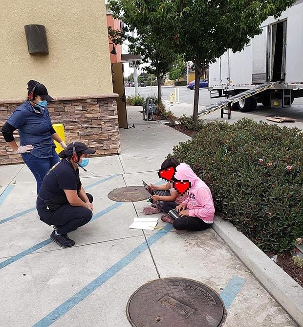 Two children outside a Taco Bell in Salinas, California using the free WiFi to do schoolwork. The poster of this image obscured the faces of these children pictured./Credit:	From Luis Alejo/Twitter
