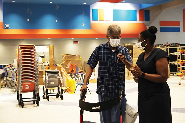 Former Sen. Henry L. Marsh III pauses to talk with Principal Kimberly Cook in the cafeteria-auditorium of the new Henry L. Marsh III Elementary School in the East End during a tour Aug. 27. Finishing touches are being made to the building that replaces the old George Mason Elementary School, which Mr. Marsh attended as a youngster.