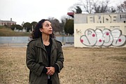 Lenora C. McQueen stands in the forgotten Grave Yard for Free People of Colour and For Slaves during a visit to Richmond. Behind her is the vacant, graffiti-marked mechanic’s shop at 1305 N. 5th St. In the background is the Hebrew Cemetery.