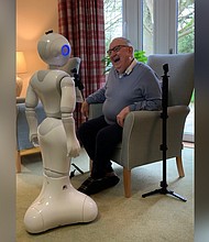 Pepper engages in conversation with a care home resident./Credit:	University of Bedfordshire