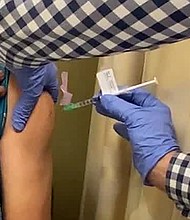 A man receives an injection as UCLA. Drug giant AstraZeneca said it had paused global trials of its coronavirus vaccine because of an unexplained illness in one of the volunteers./Credit:	The Lundquist Institute/FILE