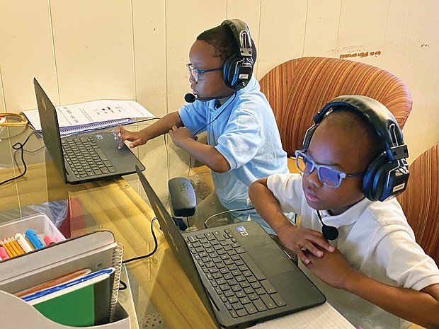 Chimborazo Elementary School students Kyle, 6, left, and Kevin Wilson, 8, connect with their teachers and classmates Tuesday, the first day of school, using Chromebooks provided by Richmond Public Schools. The kitchen table at the Wilson family’s Fulton home was turned into a virtual classroom when school began at 9:15 a.m., with mom Safiya Wilson monitoring activity.