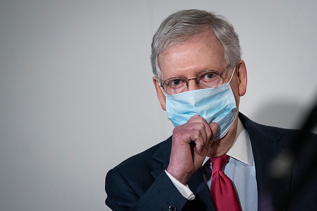 Senate Majority Leader Mitch McConnell puts on a mask after speaking to the press after a meeting with Republican Senators in the Hart Senate Office Building on Capitol Hill, May 19, 2020 in Washington, DC./Credit:	Drew Angerer/Getty Images