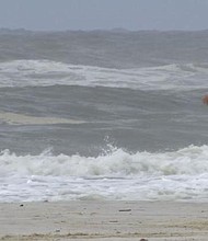 Double red flags are flying in Gulf Shores, but that didn't stop a crowd from hitting the sand./Credit:	WALA