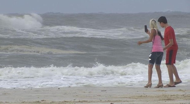 Double red flags are flying in Gulf Shores, but that didn't stop a crowd from hitting the sand./Credit:	WALA
