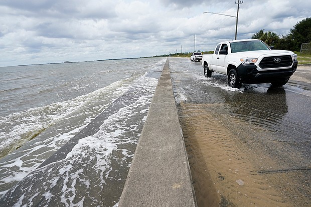 Waters from the Guld of Mexico pour onto a road Monday in Waveland, Mississippi, as Hurricane Sally closed in./Credit:	Gerald Herbrt/AP