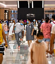 In this photo taken on September 5, 2020, people wearing face masks walk in a shopping mall in Wuhan, China's central Hubei province./Credit:	Hector Retamal/AFP/Getty Images
