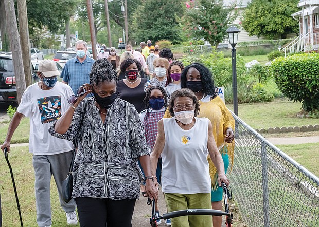 How do you honor people for making a community better?
Post an honorary street sign to recognize their contributions.
That’s what happened last Saturday in South Side as new signs saluting veteran civic leader Rosa Jones and the late Johnny R. Battle were unveiled near their homes in ceremonies spurred by 8th District City Councilwoman Reva M. Trammell.
Ms. Jones, right, who has served as president of the Oak Grove Civic Association for 20 years, is escorted to the ceremony at 1700 Fairfax Ave. by Pam Smith and dozens of others.