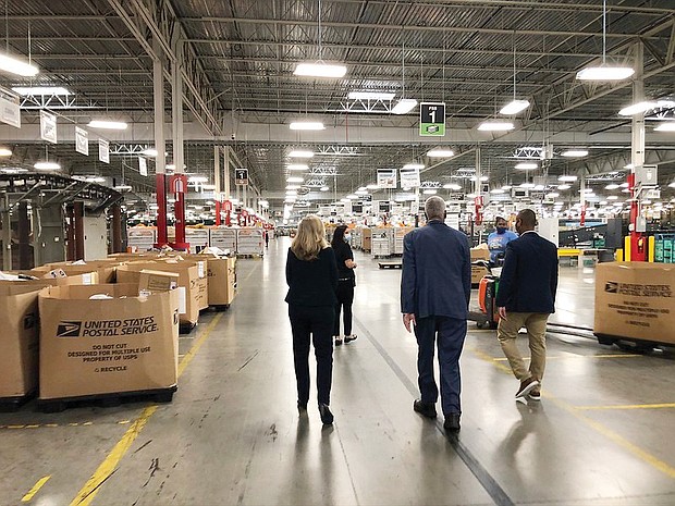Deshon Scott-Hopwood, right, senior plant manager of the U.S. Postal Service Richmond Processing and Distribution Center in Sandston, gives U.S. Reps. A. Donald McEachin, center, and Abigail Spanberger a tour of the facility on Sept. 10.