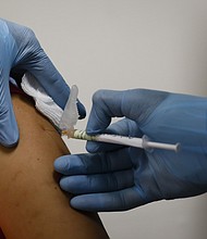 A health worker injects a woman during clinical trials for a Covid-19 vaccine at Research Centers of America in Hollywood, Florida, U.S., on Wednesday, Sept. 9, 2020. Photographer: Eva Marie Uzcategui/Bloomberg via Getty Images/Credit:	Eva Marie Uzcategui/Bloomberg via Getty Images