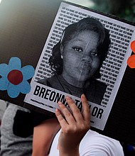 A demonstrator holds a sign with the image of Breonna Taylor, a black woman who was fatally shot by Louisville Metro Police Department officers, during a protest against the death George Floyd in Minneapolis, in Denver, Colorado on June 3, 2020./Credit:	Jason Connolly/AFP/Getty Images