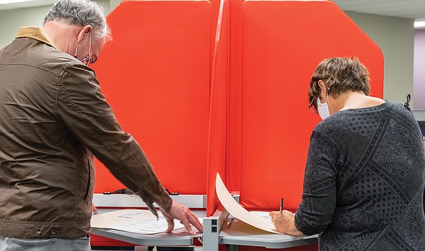 U.S. Sen. Tim Kaine and his wife, Anne Holton, former state secretary of education, mark their ballots last Friday at the Richmond Voter Registrar’s office on West Laburnum Avenue in North Side. They were among roughly 700 voters who showed up for the first day of early, in-person voting for the general election.