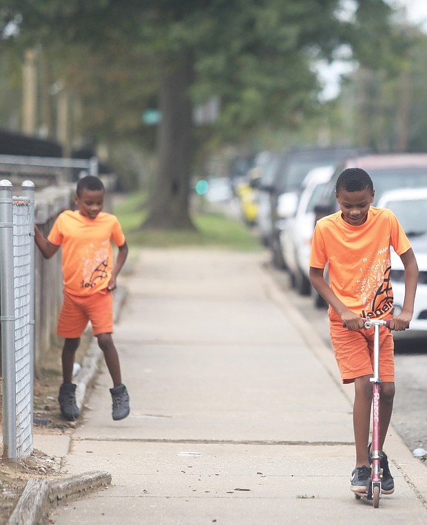Javon Davis, 10, steers a scooter as his brother, Carnell Massenburg, 8, runs alongside him near the mayor’s event at Lynhaven and Dallas avenues. The youngsters, who were taking a break from their virtual school sessions, liked the idea of a having a park near their home and said they can’t wait to play there.