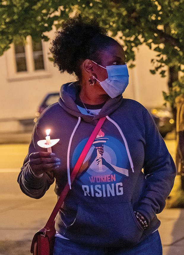 More than 100 people, including this mourner, attended a candlelight vigil Sunday outside the federal courthouse in Richmond’s Downtown to honor the life and legacy of Justice Ruth Bader Ginsburg.