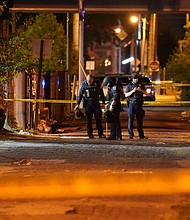 Police have arrested a 26-year-old suspect in the shooting of two police officers during protests in Louisville, Kentucky, over the charging decision in the case of Breonna Taylor. In this photo, police survey an area after a police officer was shot on Sept. 23 in Louisville, Ky./Credit: John Minchillo/AP