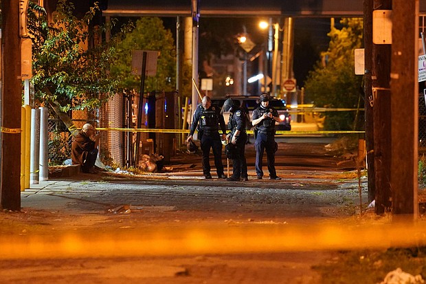 Police have arrested a 26-year-old suspect in the shooting of two police officers during protests in Louisville, Kentucky, over the charging decision in the case of Breonna Taylor. In this photo, police survey an area after a police officer was shot on Sept. 23 in Louisville, Ky./Credit: John Minchillo/AP