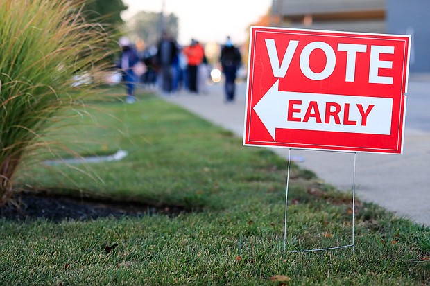 A sign for early voting is displayed as people wait in line at the Hamilton County Board of Elections to participate in early voting on October 6, 2020, in Norwood, Ohio.
Credit:	Aaron Doster/AP