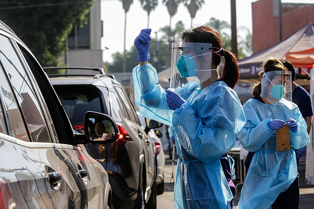 Health worker Hannah Kwon explains to a individual in car, on how to use oral swabs at a drive-thru COVID-19 test site on Oct. 3 in Los Angeles, CA.
Credit:	Irfan Khan/Los Angeles Times/Getty Images