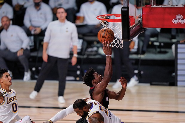 The Miami Heat’s Jimmy Butler (22) goes for a layup against the Los Angeles Lakers’ LeBron James (23) during the second half in Game 3 on Sunday of basketball’s NBA Finals in Lake Buena Vista, Fla.