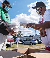 Corey Tolliver and Kevin Evans help distribute dinners to the dozens of people who attended the event.