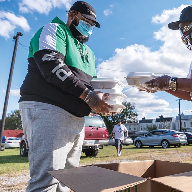 Corey Tolliver and Kevin Evans help distribute dinners to the dozens of people who attended the event.