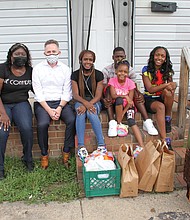 From left, Lakesha Allen, a staff member with Richmond Public Schools’ new Center for Families in Transition program, and Superintendent Jason Kamras, pause to talk after delivering food and household products to RPS parent Demeka Artis and her children, Amica, 8, Jeremiah, 14, and Kemiya, 16, at their new apartment in Highland Park.