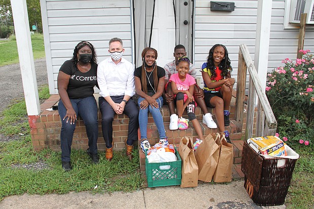 From left, Lakesha Allen, a staff member with Richmond Public Schools’ new Center for Families in Transition program, and Superintendent Jason Kamras, pause to talk after delivering food and household products to RPS parent Demeka Artis and her children, Amica, 8, Jeremiah, 14, and Kemiya, 16, at their new apartment in Highland Park.