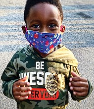 Joshua Crawford, 5, of Manchester shows off his police badge sticker Tuesday during National Night Out, the annual community-building campaign put on by police departments across the nation to promote police-community partnerships. The youngster and his mom, Chi Reed, attended the Richmond kickoff at the Jefferson Davis Civic Association event in South Side.