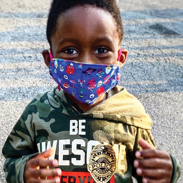 Joshua Crawford, 5, of Manchester shows off his police badge sticker Tuesday during National Night Out, the annual community-building campaign put on by police departments across the nation to promote police-community partnerships. The youngster and his mom, Chi Reed, attended the Richmond kickoff at the Jefferson Davis Civic Association event in South Side.