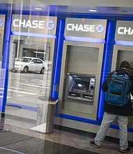 A customer uses an automated teller machine (ATM) at a temporarily closed JPMorgan Chase & Co. bank branch in New York on Friday, April 10, 2020.
Credit:	Mark Kauzlarich/Bloomberg/Getty Images