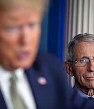 President Donald Trump, joined by members of the Coronavirus Task Force, speaks as National Institute Of Allergy And Infectious Diseases Director Dr. Anthony Fauci looks on during a press conference about the coronavirus outbreak in the press briefing room at the White House on March 17, 2020 in Washington, DC./Credit:	Drew Angerer/Getty Images