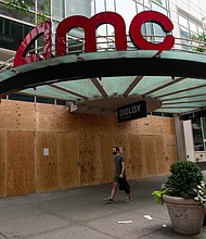 A man wearing a mask walks past a boarded up an AMC movie theater at 34th Street as the city continues Phase 4 of re-opening following restrictions imposed to slow the spread of coronavirus on September 24, 2020 in New York City.
Credit:	Alexi Rosenfeld/Getty Images