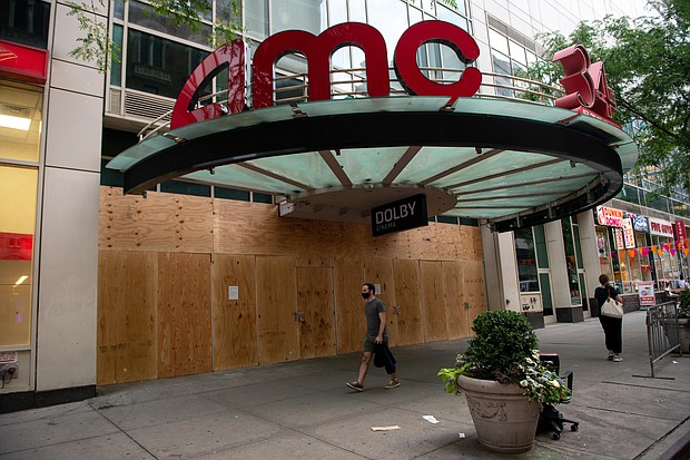 A man wearing a mask walks past a boarded up an AMC movie theater at 34th Street as the city continues Phase 4 of re-opening following restrictions imposed to slow the spread of coronavirus on September 24, 2020 in New York City.
Credit:	Alexi Rosenfeld/Getty Images