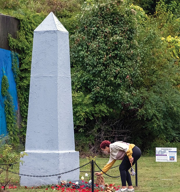 Taylor Maloney lays a white rose at the base of the obelisk honoring Richmond’s enslaved population during last Saturday’s 18th Annual Gabriel Gathering held at the burial ground for enslaved Africans in Shockoe Bottom.