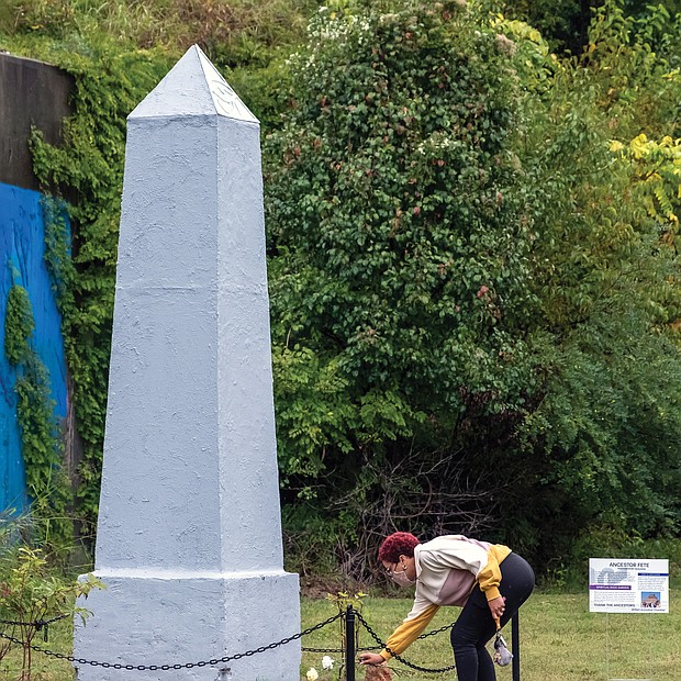 Taylor Maloney lays a white rose at the base of the obelisk honoring Richmond’s enslaved population during last Saturday’s 18th Annual Gabriel Gathering held at the burial ground for enslaved Africans in Shockoe Bottom.