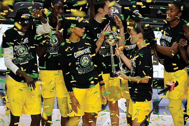 Seattle Storm guard Sue Bird shows the trophy to some of her teammates Oct. 6 after the team defeated the Las Vegas Aces to win the WNBA championship 2020, in Bradenton, Fla.