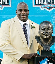 Former San Diego Chargers defensive end Fred Dean stands next to his bronze bust at his Pro Football Hall of Fame induction in 2008 in Canton, Ohio.
