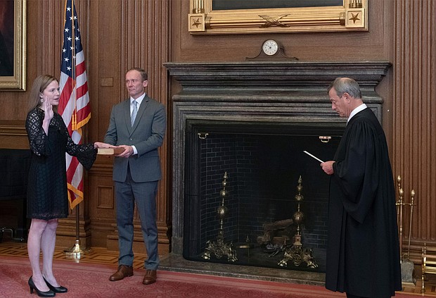Chief Justice John G. Roberts, Jr., administers the Judicial Oath to Judge Amy Coney Barrett in the East Conference Room, Supreme Court Building. Judge Barrett's husband, Jesse M. Barrett, holds the Bible.
Credit:	Fred Schilling/Collection of the Supreme Court of the United States