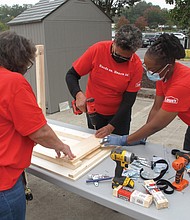 Richmond City Councilwoman Ellen F. Robertson, center, assembles a desk with the help of Anita Sawyer, left, and Fatemia Gunter, two employees of Lowe’s home improvement store. Employees at the Sheila Lane store in South Side volunteered to put together 500 fold-up desks for Richmond Public Schools students who are learning at home during the pandemic. About 25 Lowe’s employees started the project last week, with 100 desks being produced each Tuesday. The desks will be given to students free of charge.