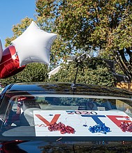 Chandra Hurst, president of the chapter, ties down balloons for the spirited, civic-minded caravan. The sorority chapter is hosting a similar event Saturday, Oct. 31, to rally voters in New Kent and Charles City counties.