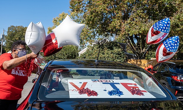 Chandra Hurst, president of the chapter, ties down balloons for the spirited, civic-minded caravan. The sorority chapter is hosting a similar event Saturday, Oct. 31, to rally voters in New Kent and Charles City counties.