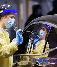 A nurse collects a sample on a patient at a drive-thru Covid-19 clinic in Montreal on October 21, 2020.
Credit:	Paul Chiasson/The Canadian Press/AP